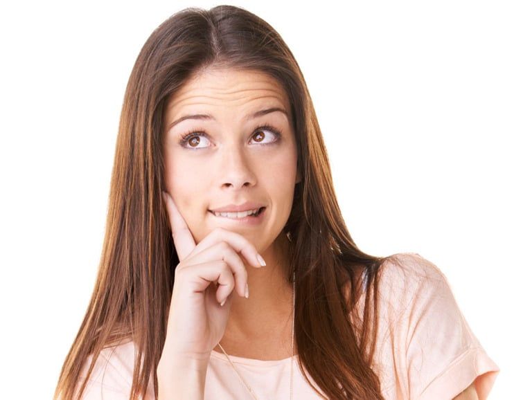 woman with her hand against the side of her face looking upwards to indicate she is thinking about something