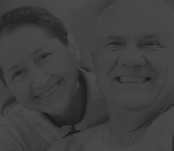 Older man and woman hugging and smiling