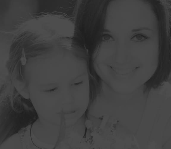 Mother and daughter sitting in a park holding flowers