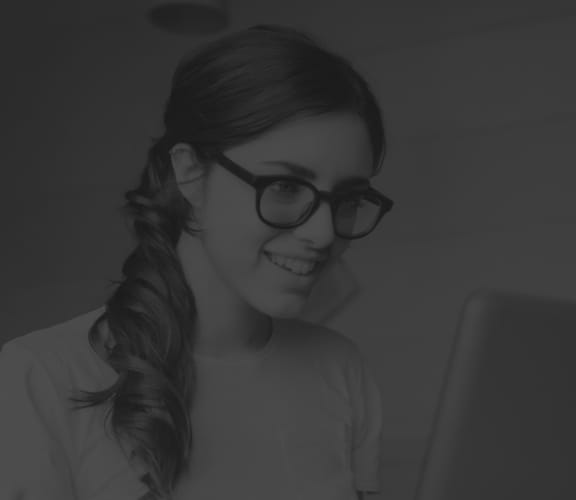 Woman looking down at her computer at her desk