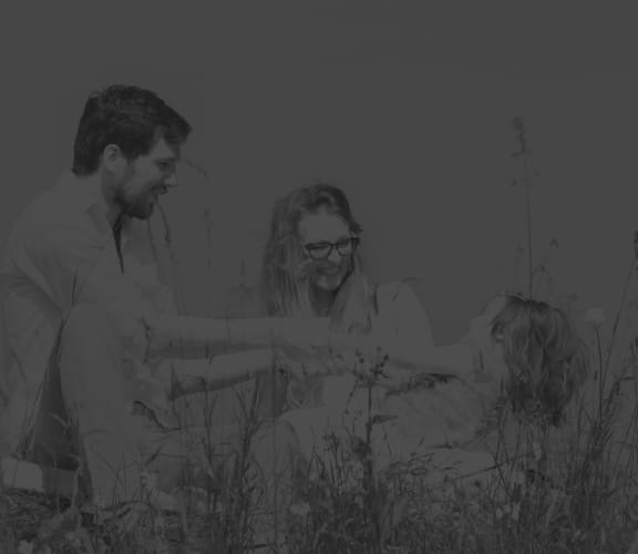 Family holding hands in a field full of flowers